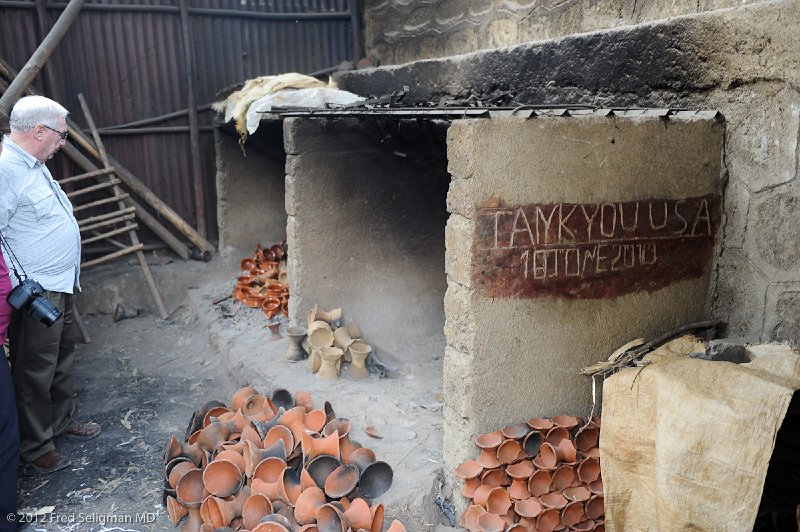 20120330_095226 Nikon D3S 2x3.jpg - Dr. Fish at the donated kiln which was able to increase the productivity of the woman.  Note the "TANK YOU USA"